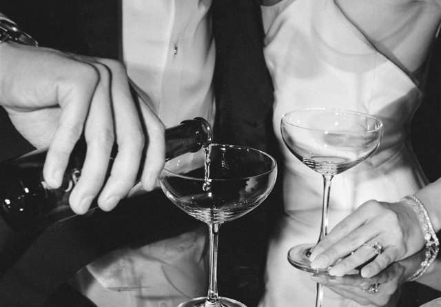 Bride and groom holding champagne glasses and groom pouring champagne at Virgin Hotels captured by Jeff Brummett