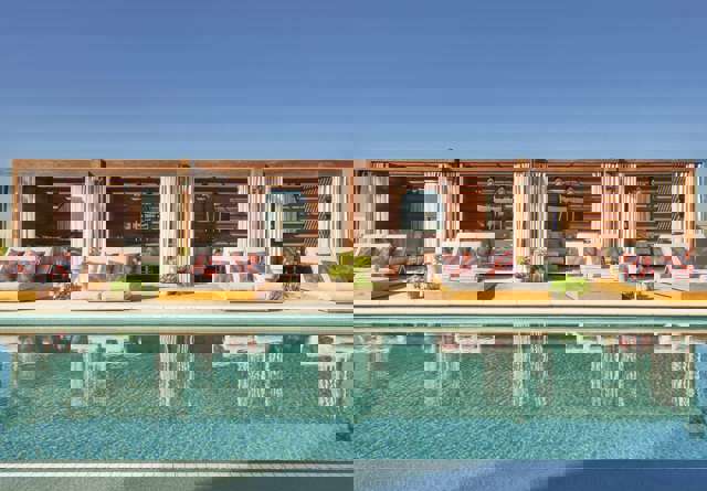 Inviting pool deck at Virgin Hotels Dallas's Pool Club, featuring stylish cabanas and a vibrant atmosphere.