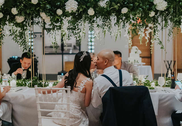 Bride and groom sat at dinner table in Virgin Hotels Nashville.