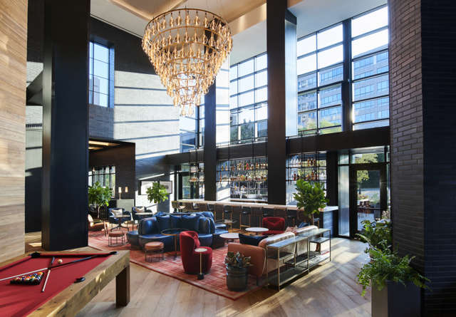 Elegant Commons Club at Virgin Hotels Nashville with plush seating, ambient lighting, and upscale decor for a refined dining experience.